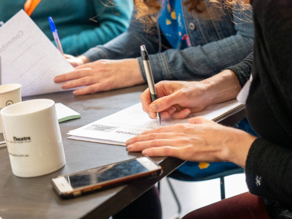 A close up of hands writing at a WHIN training workshop